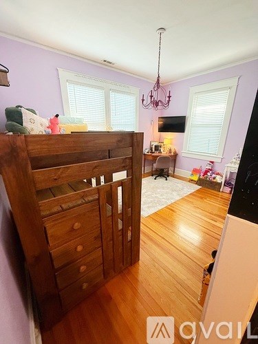 A wooden bunk bed with a chandelier hanging from the ceiling.