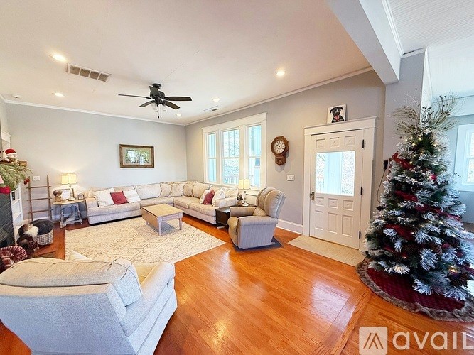 A living room with a Christmas tree and a couch.