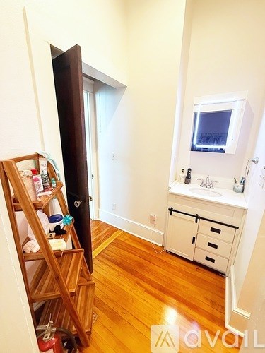 A room with a wooden ladder and a white cabinet.