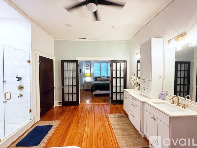 A bedroom with a bed, a vanity, and a mirror.