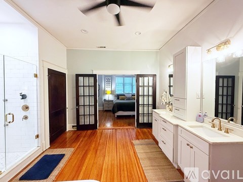 A bedroom with a bed, a vanity, and a mirror.