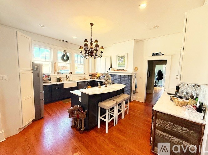 A kitchen with a wooden floor and white cabinets.