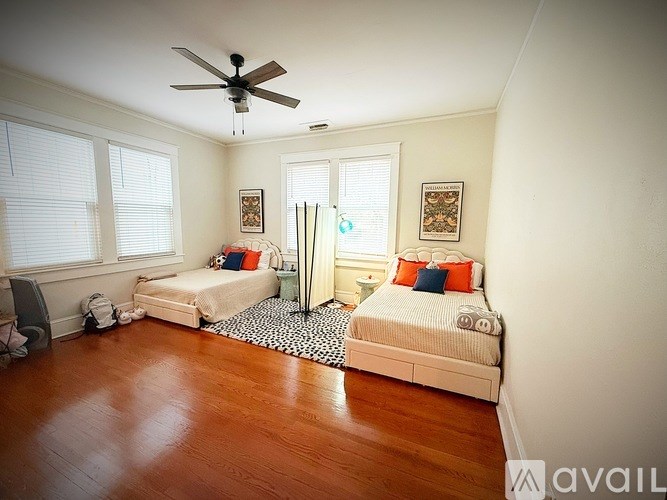 A bedroom with a bed, a ceiling fan, and a window with blinds.