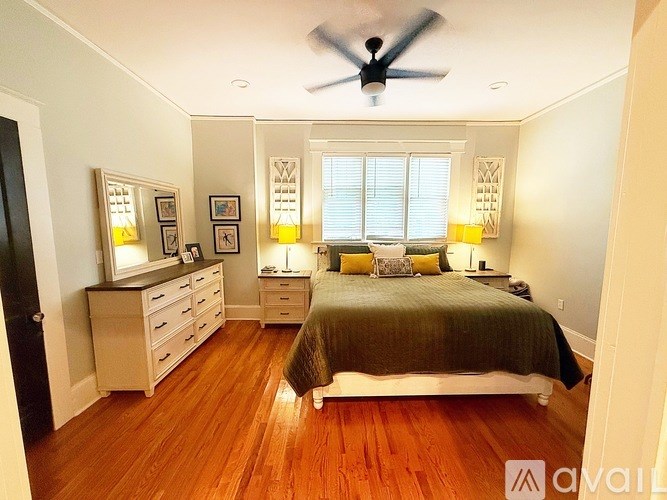 A bedroom with a bed, dresser, and mirror.