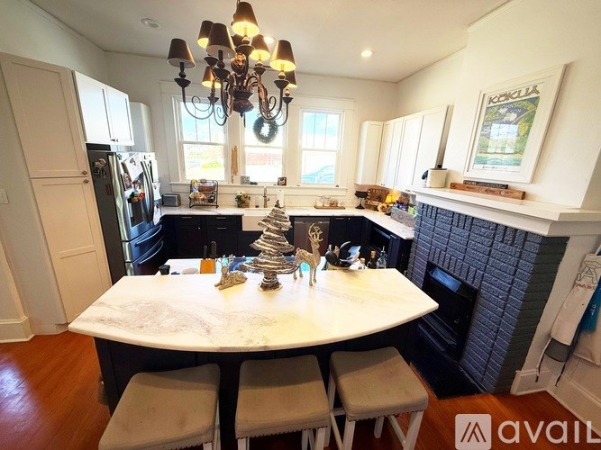 A kitchen with a table and chairs in the foreground and a fridge to the left.