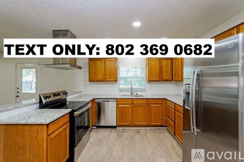 A kitchen with wooden cabinets and a stainless steel refrigerator is on the market.