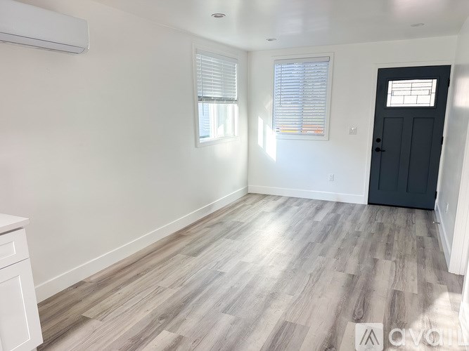A room with a wooden floor and a black door.