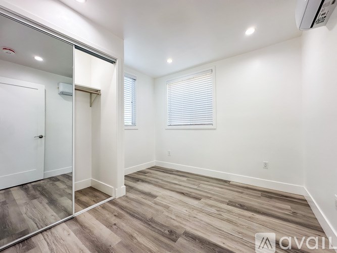 A room with a sliding glass door and wood flooring.
