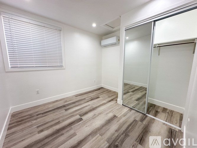 A room with a wooden floor and a sliding glass door.