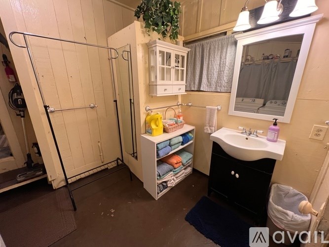 A bathroom with a sink, mirror, and shower.