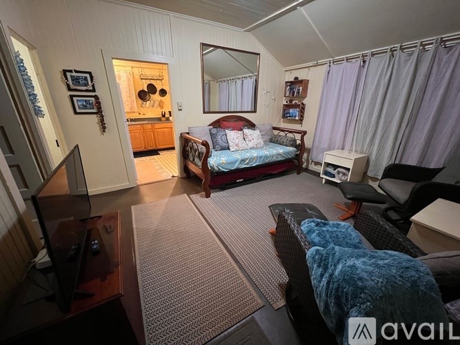 A bedroom with a bed, chair, and a mirror.