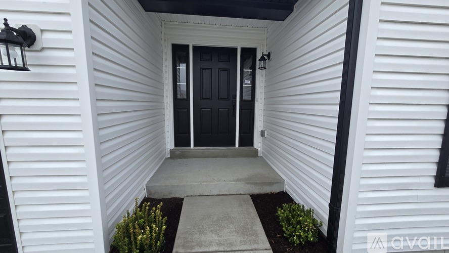 A white house with a black door and a grey step.