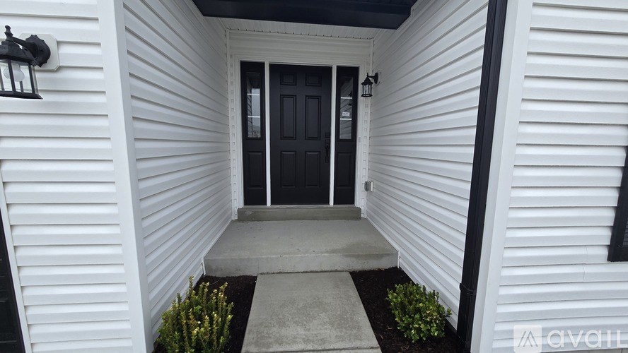 A white house with a black door and a grey step.