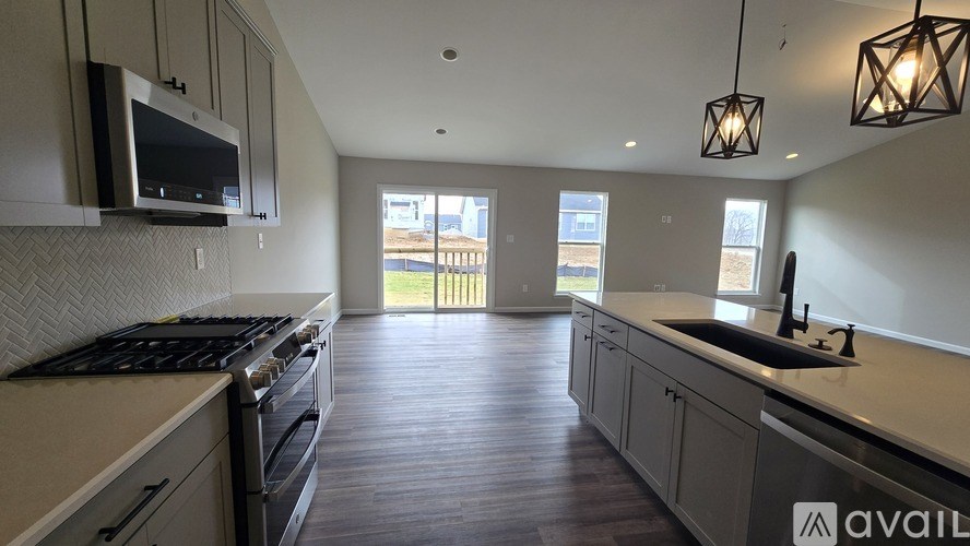 A kitchen with a black stove top oven and a microwave above it.