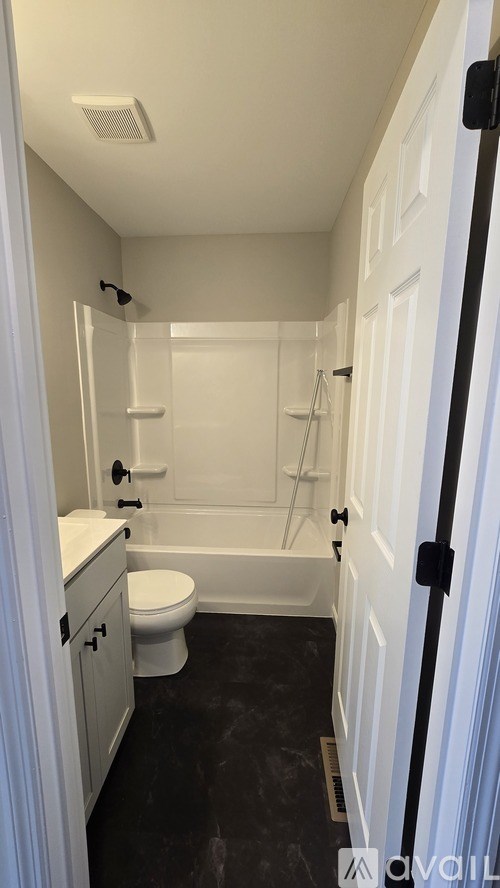 A bathroom with a toilet, sink, and bathtub.