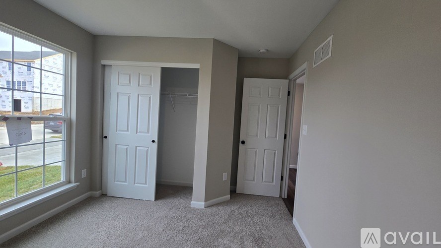 A room with two white doors and a carpeted floor.