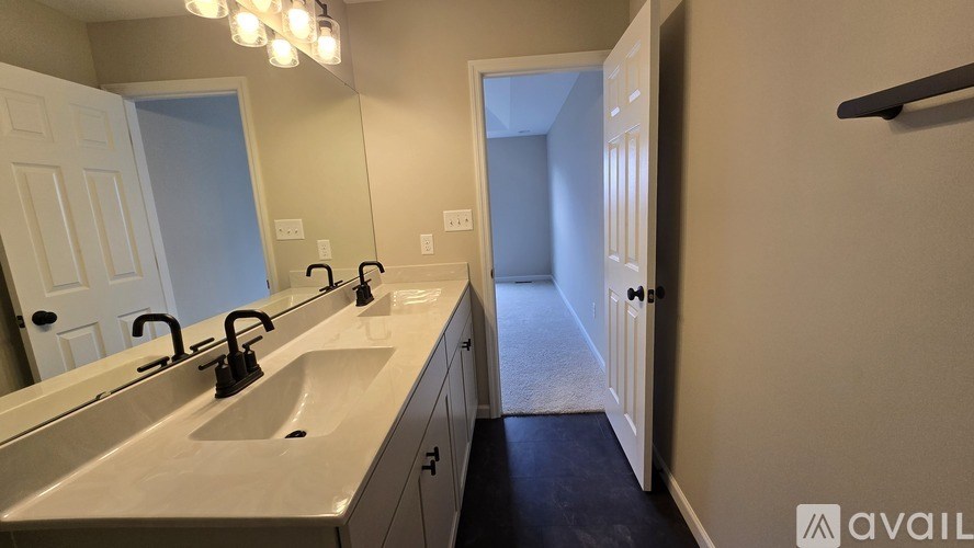 A bathroom with a double sink vanity and a mirror above it.