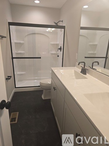 A bathroom with a sink, toilet and a glass shower stall.