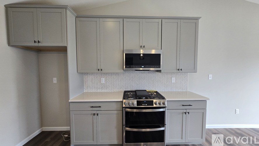 A kitchen with white cabinets and a black stove top oven.