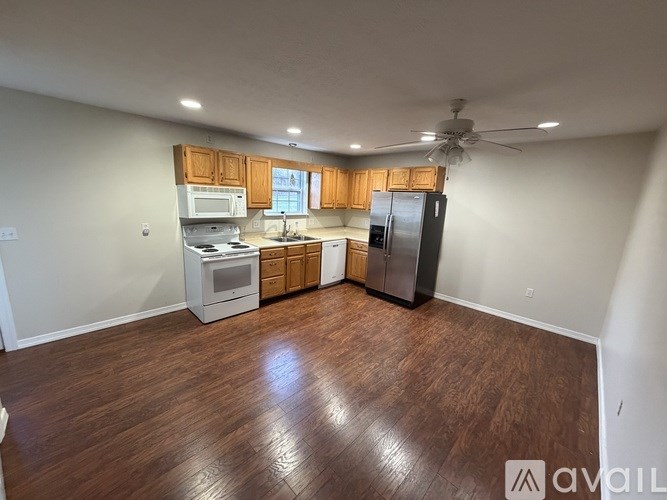 A kitchen with wooden floors and a refrigerator.