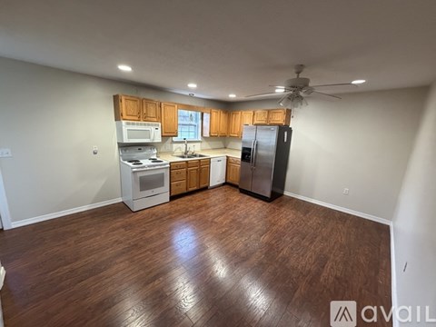 A kitchen with wooden floors and a refrigerator.