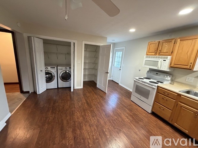 A kitchen with wooden floors and white appliances.