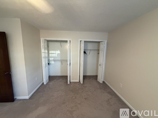 A room with two open doors and a carpeted floor.