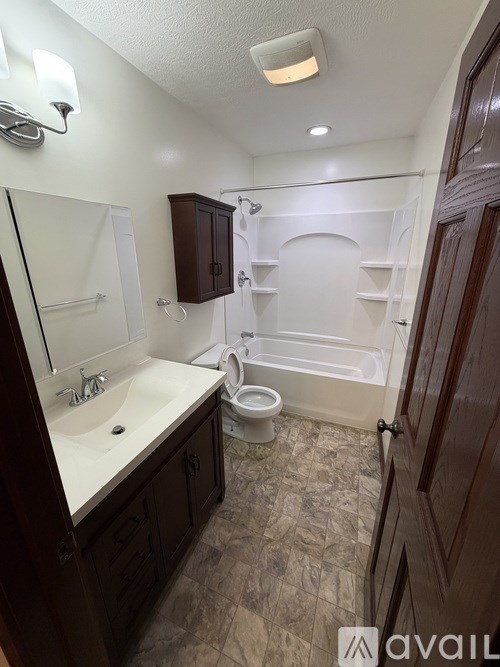 A bathroom with a toilet, sink, and bathtub.