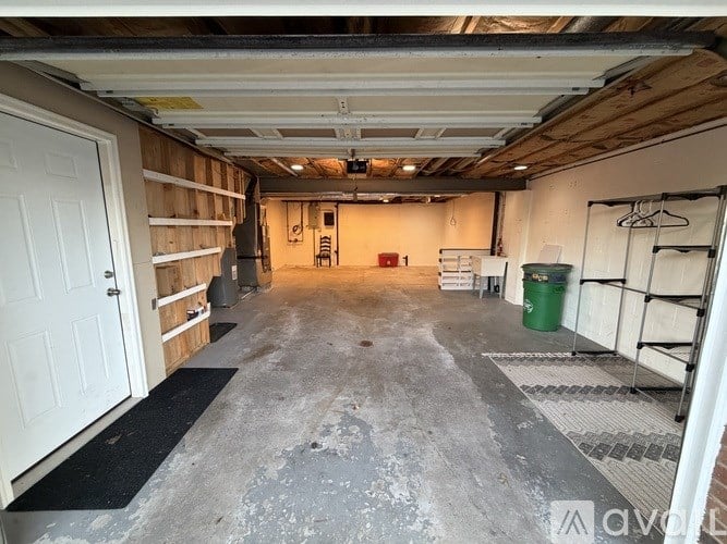 A garage with a concrete floor and a white door.