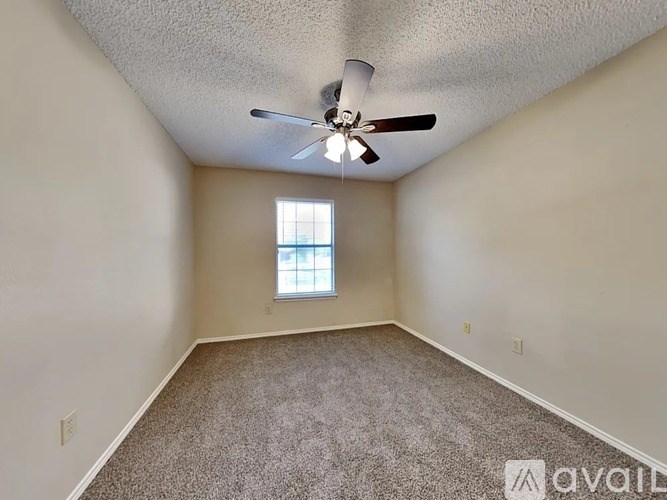 A room with a ceiling fan and a window.