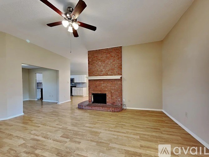 A living room with a fireplace and a ceiling fan.