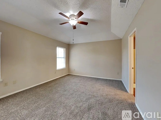 A room with a ceiling fan and carpeted floor.