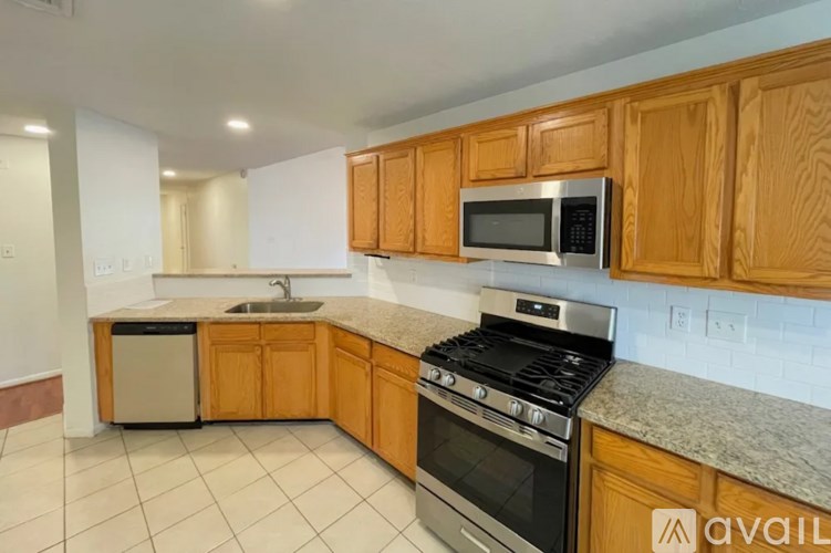 A kitchen with wooden cabinets and a granite countertop.