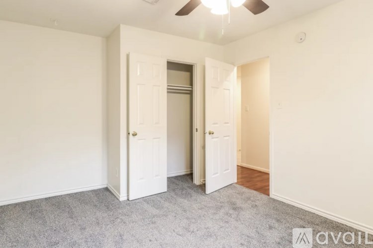 A room with a ceiling fan and two doors.