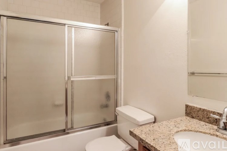 A bathroom with a toilet, sink, and shower.