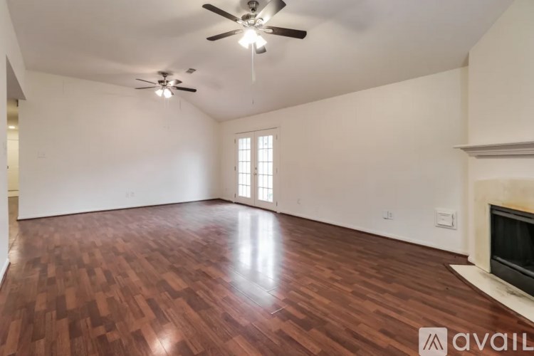 A room with wooden flooring and a ceiling fan.