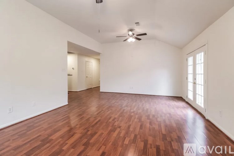 A room with wooden flooring and a ceiling fan.