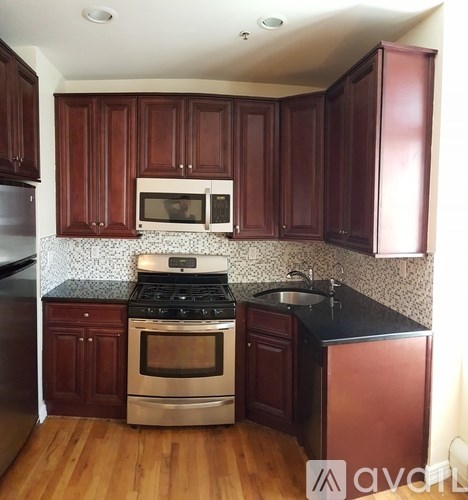A kitchen with wooden cabinets and a stove top oven.