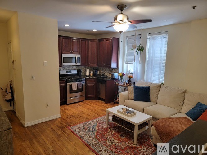 A living room with a couch, coffee table, and kitchen area in the background.