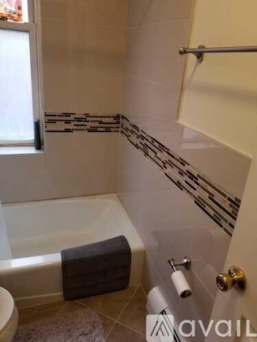 A bathroom with a white tub, toilet, and sink.