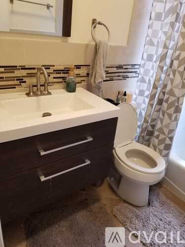 A white toilet sits next to a sink in a bathroom.