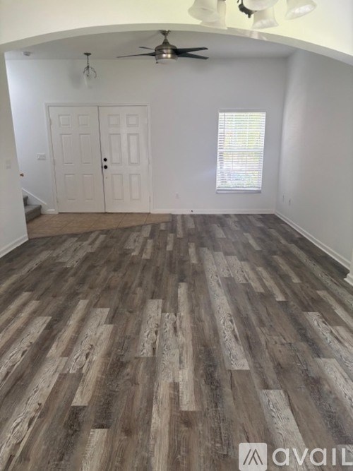 A room with wooden flooring and a ceiling fan.