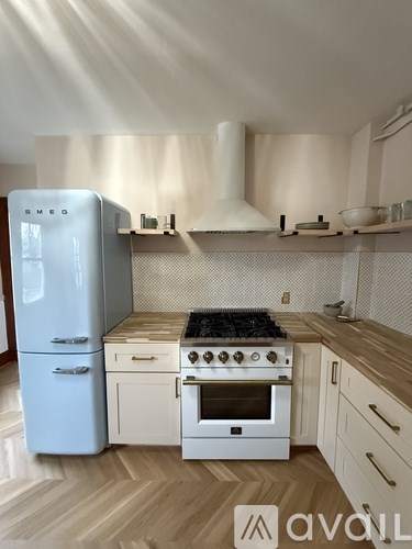 A kitchen with a blue fridge and white stove top oven.