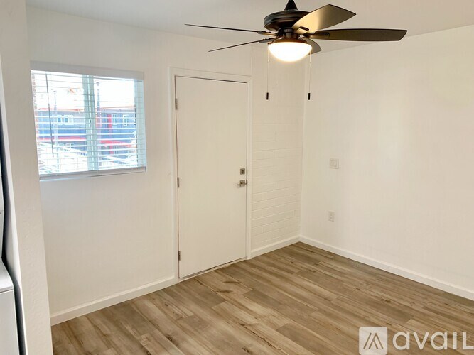 A room with a ceiling fan and wooden flooring.