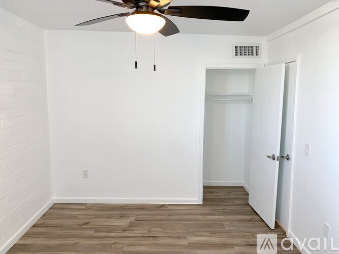 A room with a ceiling fan and a door.