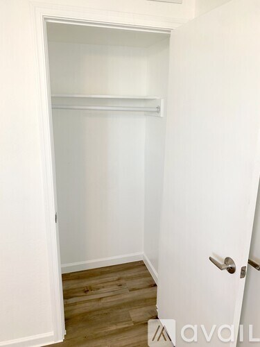 A white door with a silver handle is open to a hallway.