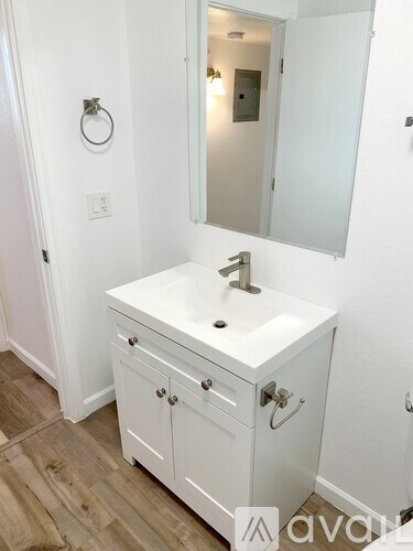A white bathroom vanity with a mirror above it.