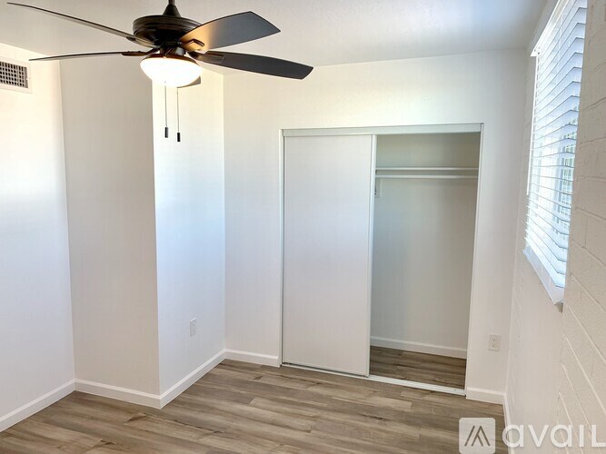 A room with a ceiling fan and a sliding door.