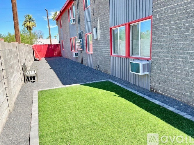 A backyard with a green lawn and a red fence.
