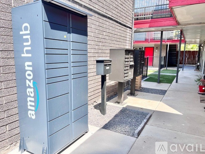 A grey Amazon hub unit is on the sidewalk.